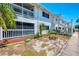 Building exterior with green space, featuring a screened-in balcony and tropical plants at 200 Rotonda W Blvd # A2, Rotonda West, FL 33947