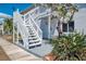 Charming exterior featuring white wooden stairs and a well-maintained landscape at 200 Rotonda W Blvd # A2, Rotonda West, FL 33947