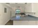 Clean kitchen boasts white cabinets, modern appliances, and a convenient breakfast bar at 200 Rotonda W Blvd # A2, Rotonda West, FL 33947