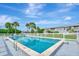 A beautiful community pool and condominium is visible with green landscaping and clear skies at 200 Rotonda W Blvd # A2, Rotonda West, FL 33947