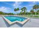 A clear view of a refreshing community pool surrounded by green landscape and palm trees at 200 Rotonda W Blvd # A2, Rotonda West, FL 33947