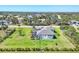 A backyard view of a single-Gathering home featuring a well-manicured lawn and a screened-in patio at 213 Sunset Rd, Rotonda West, FL 33947