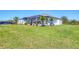 Spacious backyard featuring a screened lanai, lush lawn, and well-maintained landscaping at 213 Sunset Rd, Rotonda West, FL 33947
