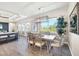 Elegant dining room with a modern light fixture, large windows, and stylish chairs at 213 Sunset Rd, Rotonda West, FL 33947