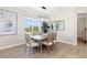 Well-lit dining area featuring a wooden table, comfortable chairs, and natural light from a large window at 213 Sunset Rd, Rotonda West, FL 33947