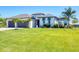Inviting home with a well-kept lawn, a gray roof, and attractive landscaping at 213 Sunset Rd, Rotonda West, FL 33947