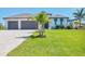 Charming home with a three-car garage, a well-manicured lawn, and inviting curb appeal at 213 Sunset Rd, Rotonda West, FL 33947