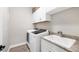 Laundry room with granite counters, sink and modern appliances at 213 Sunset Rd, Rotonda West, FL 33947