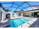 Aerial shot of in-ground screened pool with travertine tile deck and seating area at 213 Sunset Rd, Rotonda West, FL 33947