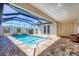 Screened-in pool area with a pool and lounging areas at 213 Sunset Rd, Rotonda West, FL 33947