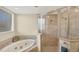 Bright bathroom featuring a soaking tub, glass-enclosed shower, and neutral tile at 25 Medalist Ter, Rotonda West, FL 33947