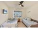 Comfortable guest bedroom with ceiling fan, twin beds, and a bright window at 25 Medalist Ter, Rotonda West, FL 33947