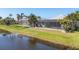 Beautiful home exterior featuring a screened pool, lush landscaping, and tranquil water views at 25 Medalist Ter, Rotonda West, FL 33947