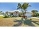 Charming single-story home with a metal roof, lush landscaping, and a welcoming front porch at 25 Medalist Ter, Rotonda West, FL 33947