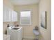 Functional laundry room with washer, dryer, cabinetry, and natural lighting at 25 Medalist Ter, Rotonda West, FL 33947