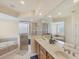 Well-lit main bathroom with double sinks, soaking tub, and glass-enclosed shower at 25 Medalist Ter, Rotonda West, FL 33947