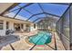 Sparkling pool with screened enclosure, lounge chairs, and serene water view at 25 Medalist Ter, Rotonda West, FL 33947
