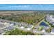 Stunning aerial view of a cozy neighborhood with lush greenery, mature trees, and a serene pond at 284 Talquin Ct, Englewood, FL 34223