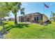 Charming single-Gathering home featuring a spacious screened-in lanai, green lawn, and flowering bushes at 284 Talquin Ct, Englewood, FL 34223