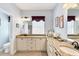 Bright bathroom featuring double vanities, granite counters, and coastal decor accents at 284 Talquin Ct, Englewood, FL 34223