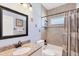 Bathroom with granite countertop, framed mirror, and tiled shower with curtain at 284 Talquin Ct, Englewood, FL 34223