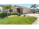 Charming single-Gathering home with a well-maintained lawn, mature landscaping, and a paved driveway leading to a two-car garage at 284 Talquin Ct, Englewood, FL 34223