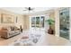 Bright living room with neutral tones, stylish rug, and large sliding glass doors to let in natural light at 284 Talquin Ct, Englewood, FL 34223