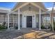 Inviting front entryway with a modern door, white pillars, and lush landscaping at 400 Anchor Row, Placida, FL 33946