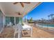 Covered patio with ceiling fans, outdoor seating, and views of the pool and waterfront at 400 Anchor Row, Placida, FL 33946