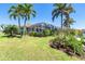 Landscaped backyard featuring tropical landscaping and a screened in pool enclosure at 471 Capri Isles Ct, Punta Gorda, FL 33950