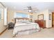 Cozy bedroom featuring a queen bed, ceiling fan and large window with curtains at 471 Capri Isles Ct, Punta Gorda, FL 33950