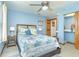Comfortable bedroom features a ceiling fan, blue walls, and a charming patchwork quilt on the bed at 471 Capri Isles Ct, Punta Gorda, FL 33950