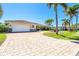Inviting single-story home featuring a paved driveway and tropical landscaping at 471 Capri Isles Ct, Punta Gorda, FL 33950