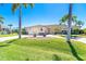 Charming single-story home featuring a well-manicured lawn, mature palms, and a circular driveway at 471 Capri Isles Ct, Punta Gorda, FL 33950