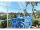 The outdoor seating area features a bright blue table and chairs under a screened enclosure at 471 Capri Isles Ct, Punta Gorda, FL 33950