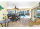 Screened-in patio with view of the pool, dining table and comfortable seating area at 471 Capri Isles Ct, Punta Gorda, FL 33950