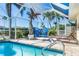 The screened-in pool area is decorated with tropical themed furniture and landscaping at 471 Capri Isles Ct, Punta Gorda, FL 33950