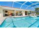 Inviting pool area with outdoor kitchen, bar, and covered patio space for entertaining and relaxation at 471 Capri Isles Ct, Punta Gorda, FL 33950