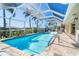 A view of the enclosed pool with cool deck, clear blue water and tropical landscaping at 471 Capri Isles Ct, Punta Gorda, FL 33950