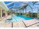 Enclosed pool with cool deck, a clear blue water, a swan floatie and tropical landscape at 471 Capri Isles Ct, Punta Gorda, FL 33950