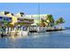 Charming waterfront building, featuring boats docked along a scenic pier with palm trees on a sunny day at 471 Capri Isles Ct, Punta Gorda, FL 33950