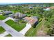 Aerial view of a beautiful home with a pool and manicured lawn nestled in a lush, green neighborhood at 5 Pine Valley Rd, Rotonda West, FL 33947