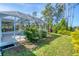 Backyard with an enclosed lanai and greenery at 5 Pine Valley Rd, Rotonda West, FL 33947