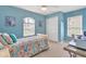 Bright blue bedroom with a bed, two windows, closet, and desk area at 5 Pine Valley Rd, Rotonda West, FL 33947
