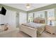 Cozy bedroom with a queen-sized bed, ceiling fan, and a bay window providing natural light at 5 Pine Valley Rd, Rotonda West, FL 33947