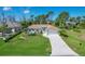Charming home featuring a well-maintained lawn, lovely landscaping, and a long driveway leading to the garage at 5 Pine Valley Rd, Rotonda West, FL 33947