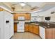 Open-concept kitchen with wooden cabinets, white appliances, and granite countertops at 5 Pine Valley Rd, Rotonda West, FL 33947