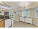 Kitchen with white cabinetry and adjacent dining area featuring a large window and neutral decor at 5 Pine Valley Rd, Rotonda West, FL 33947