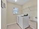 Functional laundry room featuring a washer, dryer, utility sink, window, and storage shelf at 5 Pine Valley Rd, Rotonda West, FL 33947