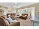 Comfortable living room with plush brown couches, natural light from large windows, and ceiling fan at 5 Pine Valley Rd, Rotonda West, FL 33947